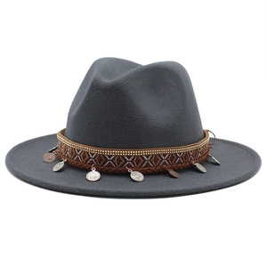 Detail of dark grey fedora with ethnic woven band and retro metallic coin pendants