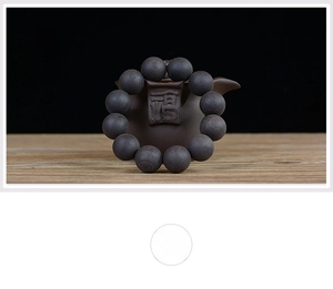 Macro detail of natural unfinished African Blackwood prayer beads on a wooden base