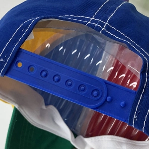 Detail of adjustable snapback closure on a colorful propeller baseball cap with white stitching