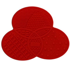 Vista macro del tappetino in silicone rosso per la pulizia dei pennelli con texture a trifoglio