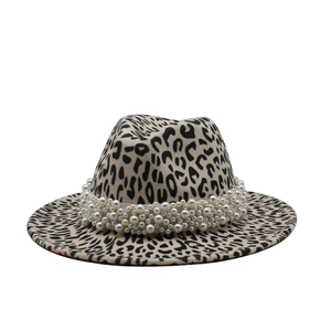 Détail du chapeau fedora léopard avec plusieurs rangées de perles sur le bandeau