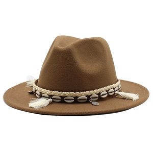 Detail of wool fedora hat featuring ethnic shell trim and white fringe tassel decor