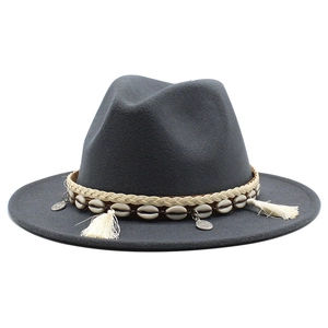 Detail of dark gray wool fedora featuring ethnic braided band with shells and coins