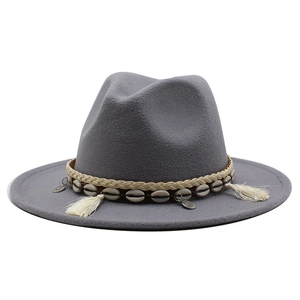 Close-up of grey wool fedora featuring ethnic woven band with shells and tassel charms