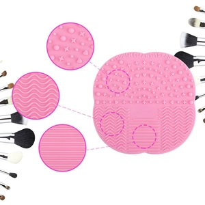 Pink silicone makeup brush cleaning pad with suction cup and varied textures for deep cleansing