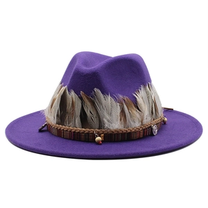 Dettaglio del cappello fedora viola con piume stratificate e fascia stile boho