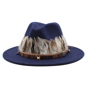 Dettaglio di cappello fedora blu scuro con decorazione piuma e cinturino bohémien