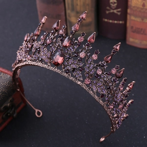 Detailed close-up of Baroque bridal tiara with purple rhinestones on vintage books