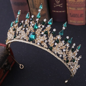 Detailed side view of baroque crown with emerald crystals and white rhinestones