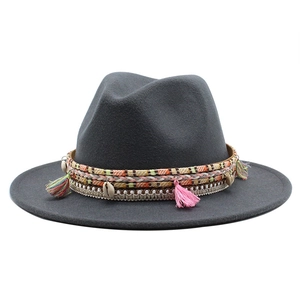 Close-up of grey wool fedora featuring colorful ethnic tassels and natural shell accents