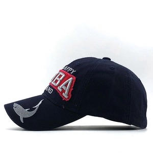 Détail de la broderie requin et des écussons sur une casquette en coton bleu marine