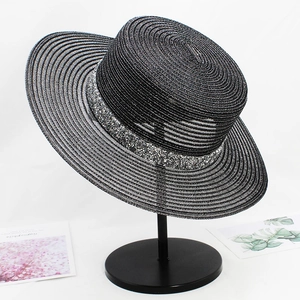 Detail of black straw flat top hat with sparkling silver sequin band on display stand
