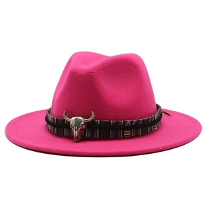 Detail of hot pink fedora featuring a tribal woven band and silver bull skull ornament