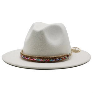 Detail of bohemian fedora hat featuring beaded bands and metallic pendant on wool felt