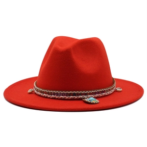 Macro shot of red wool fedora hat featuring ethnic woven band and seashell turquoise detail