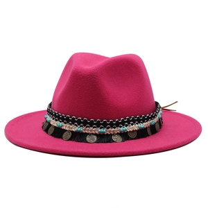 Dettaglio di cappello fedora in lana con perle turchesi e nappa con monete metalliche