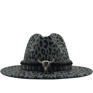 Détail du chapeau fedora léopard avec bande tressée ethnique et tête de taureau en métal