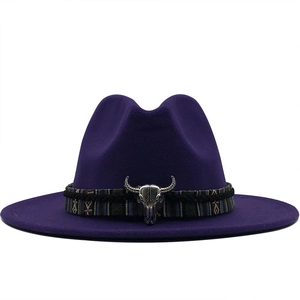 Détail d'un chapeau en laine avec ruban ethnique et ornement métallique de tête de buffle