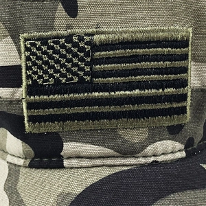Detailed macro shot of tactical flag patch and camouflage fabric on a cotton army cap