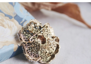 Detailed back view of vintage flower brooch showing golden alloy镂空 metalwork and secure pin