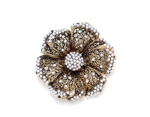 Detailed macro view of vintage gold flower brooch with pearls and filigree wire craft
