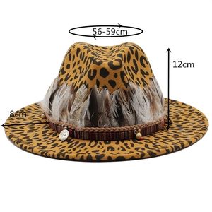 Detail of leopard print fedora hat featuring feather band and metal coin charms