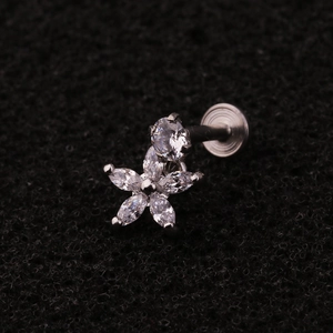 Macro shot of silver flower piercing with marquise cubic zirconia on black sponge