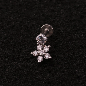 Macro shot of silver stainless steel labret stud featuring a floral zircon dangle charm