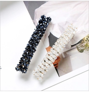 Close-up of crystal spring hair clips in black and clear white with four rows of rhinestones