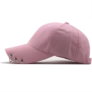 Detail of pink cotton baseball cap featuring three silver metal rings on the brim