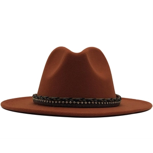 Detailed view of the dark braided band with rhinestones on a rust-red fedora hat