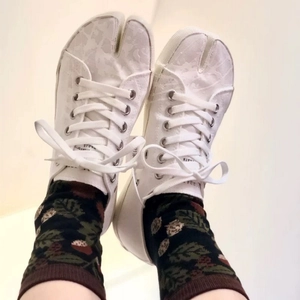 Close-up of white canvas Tabi shoes paired with jacquard pattern split-toe socks