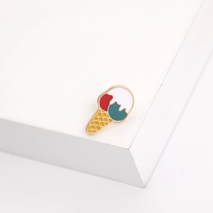 Macro shot of an ice cream shaped metal brooch with colorful enamel on a white stand