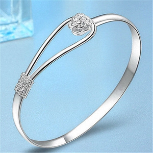 Elegant silver open bangle featuring detailed rose flower design and textured braided band