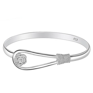 Macro detail of silver rose charm bangle with S925 hallmark and twisted wire design