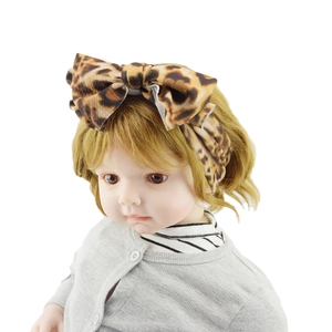 Detail showing high-quality leopard print fabric headband with large bow on child model