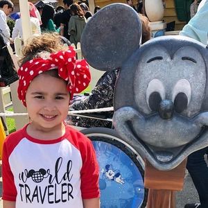 Detail of red and white polka dot bow headband on a young girl in an outdoor setting