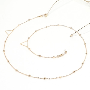 Detail of golden glasses chain with triangle charms and small metal beads on white base