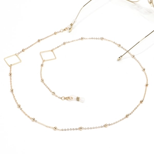 Detail of golden glasses chain with geometric square beads and silicone anti-slip loops