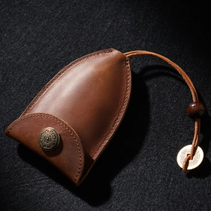 Macro shot of brown crazy horse leather tape measure case with vintage wooden bead and metal ring
