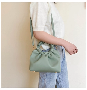 Detail of mint green cloud bag featuring pleated ring handle and adjustable strap