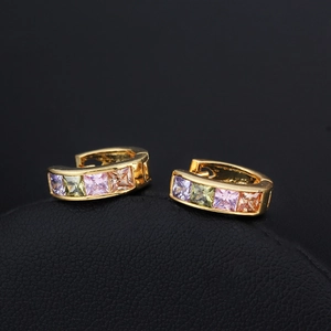 Macro shot of colorful square-cut zircon stones set in 18K gold-plated hoop earrings
