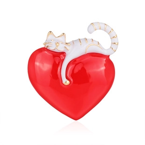 Detail of red enamel heart brooch with a white cat design and golden metal outlines