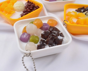 Macro shot of realistic dessert pendant models including grass jelly and mango sago