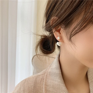 Close-up of heart pearl drop earrings with golden rod on model for daily wear