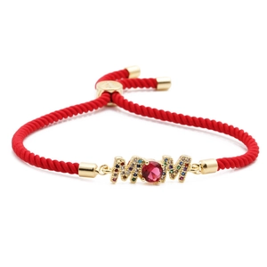 Detailed shot of handmade red braided cord bracelet with gold MOM charm and colorful zircons