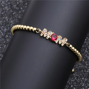 Detail of MOM letter bracelet with pavé colorful zircon and large red center stone