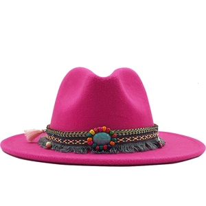Detail of magenta wool fedora featuring ethnic embroidery and turquoise stone