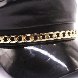 Detail view of black PU leather baker boy hat with glossy brim and gold chain accent
