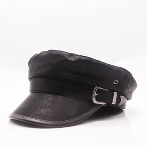 Detail of black leather newsboy cap showing metallic decorative buckle and side ventilation